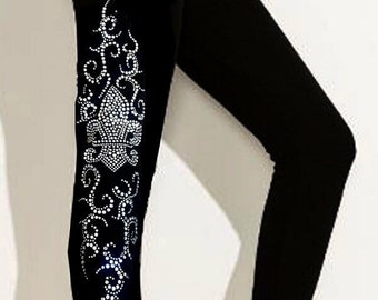Puede incluir: Leggings negros con un diseño de pedrería plateada en la pierna izquierda.