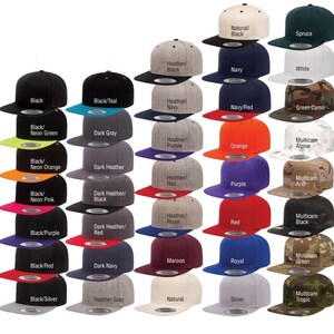 Puede incluir: Una colecci&oacute;n de gorras de b&eacute;isbol de ala plana en varios colores, incluyendo negro, azul marino, rojo y camuflaje verde. Cada gorra presenta una visera en contraste y un dise&ntilde;o estructurado, con nombres de colores impresos.