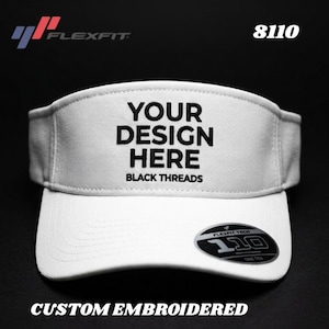 May include: White Flexfit visor with the text "YOUR DESIGN HERE BLACK THREADS" embroidered on the front. The visor has a curved brim and a Flexfit Tech 110 sticker. The product code "8110" is visible.