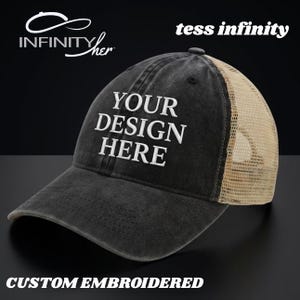 Puede incluir: Gorra de camionero negra con la parte trasera de malla beige. La parte delantera de la gorra tiene el texto blanco "YOUR DESIGN HERE". Las palabras "CUSTOM EMBROIDERED" están en la parte inferior. La gorra también tiene el texto "tess infinity" y el logotipo Infinity her.