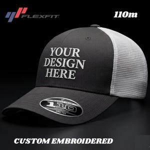 Può includere: Cappellino da baseball Flexfit 110m grigio antracite con retro in rete bianca. Il cappellino presenta la scritta "YOUR DESIGN HERE" in ricamo bianco. La visiera ha un'etichetta Flexfit Tech 110 One Ten. Le parole "CUSTOM EMBROIDERED" sono in basso.