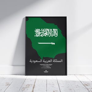 Könnte beinhalten: Ein schwarzer gerahmter Poster mit einer grünen Umrandung des Königreichs Saudi-Arabien. Die Flagge Saudi-Arabiens ist innerhalb der Umrandung dargestellt. Der arabische Text "المملكة العربية السعودية" ist unter der Flagge dargestellt, was "Königreich Saudi-Arabien" bedeutet.