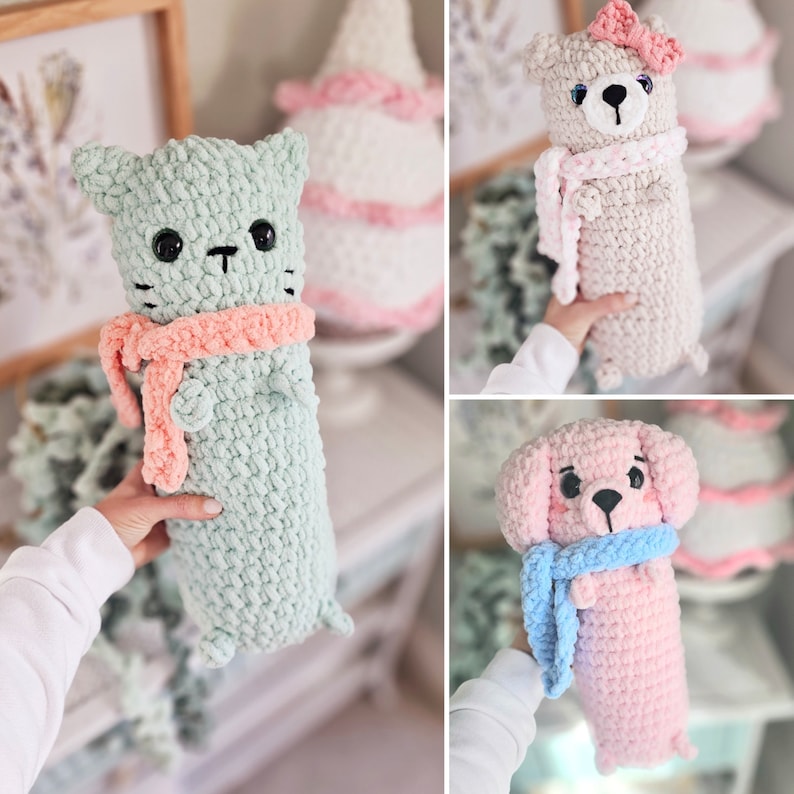 May include: Three crocheted stuffed animals wearing scarves. A light green cat, a light pink dog, and a cream colored bear.