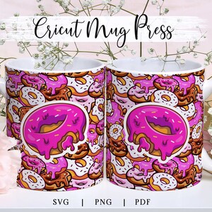 May include: Two white ceramic mugs with a colorful donut pattern. The mugs feature a repeating design of various donuts in shades of pink, brown, and white. A large pink donut graphic is centered on each mug. The text "Cricut Mug Press" is at the top.