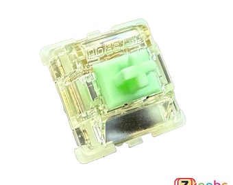 May include: A clear plastic mechanical keyboard switch with a green stem and the text "HOLTEK" printed on the top.
