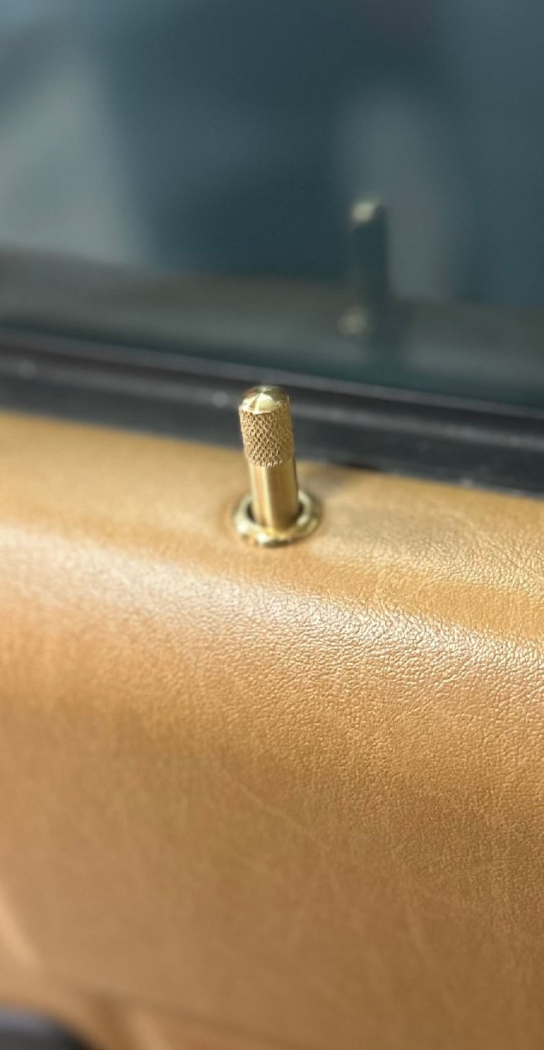 Puede incluir: Una manija de puerta dorada con un pomo moleteado.