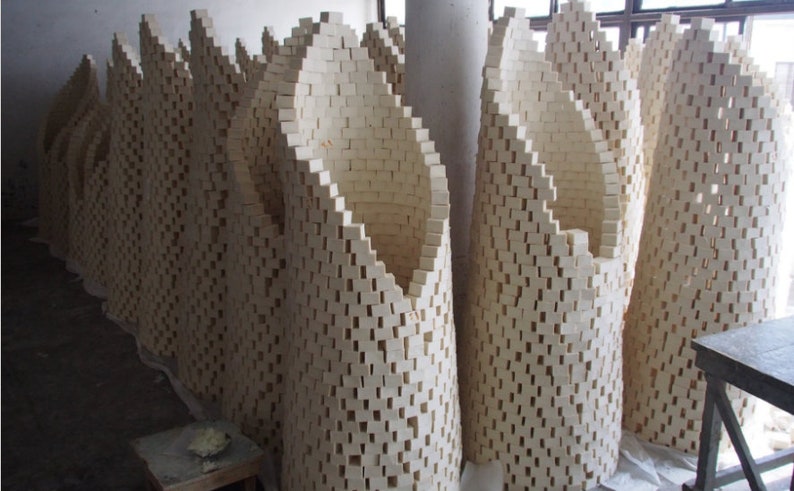 May include: A large group of white soap bars stacked in a curved, arch-like formation. The bars are arranged in a grid pattern, creating a unique and visually appealing display.