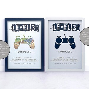 Op de afbeelding: Twee ingelijste prints met een zwart-witte afbeelding van een videogamecontroller en de tekst "LEVEL 30 - COMPLETE -"  De tekst onder de afbeelding luidt "Lieber Marco, zu deinem 30. Geburtstag w&uuml;nschen wir dir alles gute Sarah und Martin".