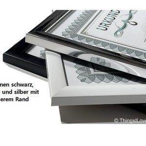 May include: Three picture frames stacked on top of each other. The top frame is silver, the middle frame is white, and the bottom frame is black. The frames have a wide border. The text "URKUND" is visible on the top frame.
