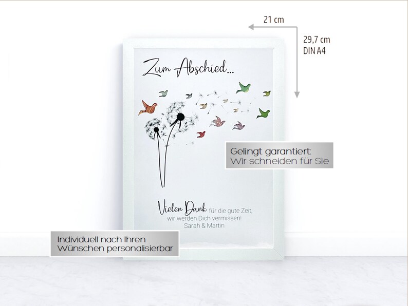 May include: A white frame with a white mat and a printed image of a dandelion with colorful birds flying away. The text "Zum Abschied..." is at the top of the image. The text "Vielen Dank f&uuml;r die gute Zeit. wir werden Dich vermissen! Sarah & Martin" is at the bottom of the image. The text "Individuell nach Ihren W&uuml;nschen personalisierbar" is at the bottom of the frame. The frame is 21 cm by 29.7 cm.