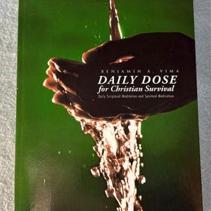 May include: A book cover with the title "DAILY DOSE for Christian Survival" by Benjamin A. Vima. The cover features a dark hand catching water pouring from above against a green background. The book's subtitle reads "Daily Scriptural Meditation and Spiritual Medication."