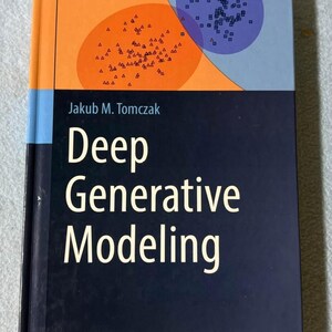 May include: A hardcover book titled Deep Generative Modeling by Jakub M. Tomczak, published by Springer. The cover features a dark blue lower section with white text and an upper section with orange and purple circular shapes containing small symbols.