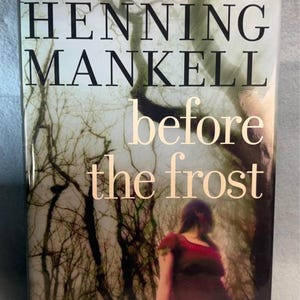 May include: A book cover for "Before the Frost" by Henning Mankell. The title is in large, light-colored letters against a backdrop of bare trees and a blurred figure. The cover also includes a quote from The Los Angeles Times Book Review.