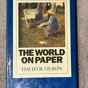 May include: A blue hardcover book with the title "The World on Paper" by David R. Olson. The cover features a painting of a person painting outdoors.