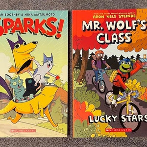 May include: Two children's graphic novels, one titled "Sparks!" with a yellow dog and two cats on a yellow vehicle, and the other titled "Mr. Wolf's Class: Lucky Stars" with a frog character riding a bicycle.