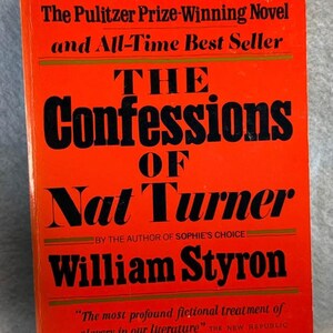 May include: A paperback book titled "The Confessions of Nat Turner" by William Styron. The cover is bright red with black text, including the title, author's name, and a quote. The book is a Pulitzer Prize-Winning Novel and All-Time Best Seller.