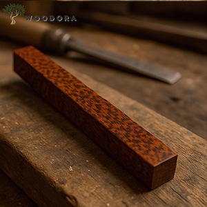 May include: A close-up of a rectangular piece of wood with a reddish-brown color and a unique, intricate grain pattern. The wood is smooth and polished, and it appears to be a high-quality piece of lumber.