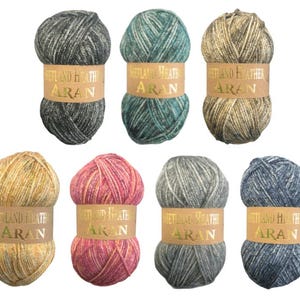 May include: Eight balls of Aran weight yarn in shades of grey, teal, beige, yellow, pink, and blue. Each ball has a paper band with the text "Shetland Heath Aran". Suitable for knitting and crochet projects.