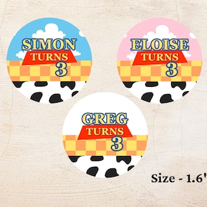 May include: Three circular stickers with a Toy Story theme. Each sticker has a different name: Simon, Eloise, and Greg. The text "TURNS 3" is included on each sticker. The background includes a blue sky, pink sky, and a cow print.