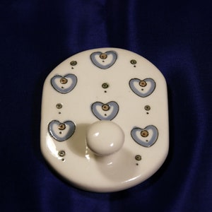 May include: White ceramic hook with a knob and a blue and gold heart pattern.