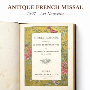 Puede incluir: Un misal francés antiguo de 1897 abierto, con el título "MISSEL ROMAIN" y el texto "LES OFFICES DES PRINCIPALES FÊTES". La portada está decorada con diseños florales rosas y verdes, con detalles dorados. El libro está en buen estado.
