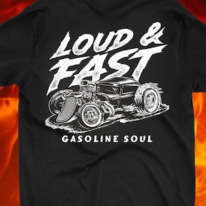 以下が含まれることがあります： 黒いTシャツに、白いホットロッドの車のグラフィックがプリントされています。車の下に「Loud & Fast」と「Gasoline Soul」の文字があります。