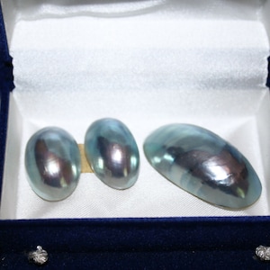 Peut inclure: Trois perles ovales bleu-vert irisées dans un écrin à bijoux en velours bleu.