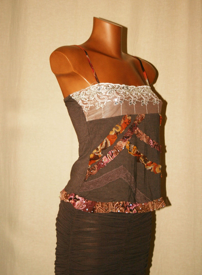 May include: A brown sleeveless top with a lace trim and a brown skirt. The top has a patchwork design with brown, orange, and pink fabric.