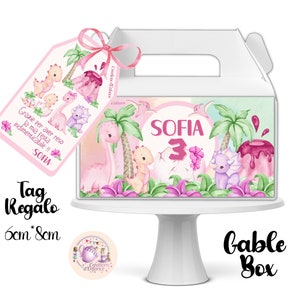 Può includere: Scatola a forma di gable rosa e verde a tema dinosauri con un'etichetta abbinata. La scatola ha un manico ed è decorata con un dinosauro rosa, un vulcano e palme. L'etichetta dice "Grazie per aver reso la mia festa indimenticabile!! -SOFIA-." La scatola misura 6 cm per 8 cm.