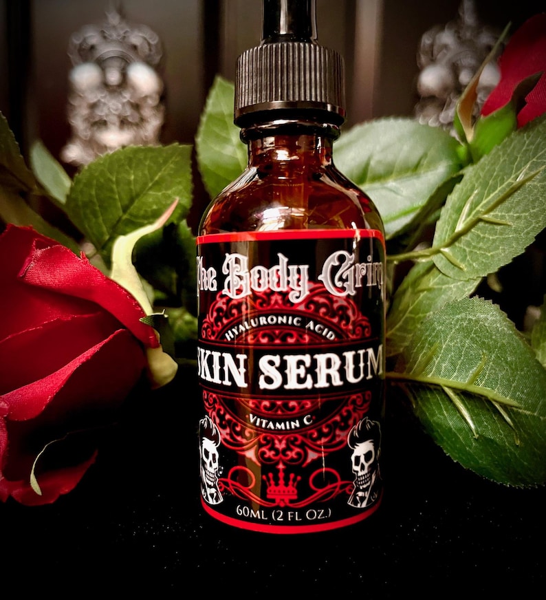 May include: A dark brown glass bottle with a black dropper top and a red and black label that reads "The Body Grip Hyaluronic Acid Skin Serum Vitamin C 60ML (2 FL OZ.)".