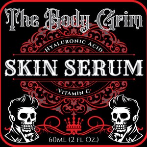 May include: Black and red label with ornate design featuring a skull graphic and the text "The Body Grim SKIN SERUM HYALURONIC ACID VITAMIN C 60ML (2 FL OZ.)"