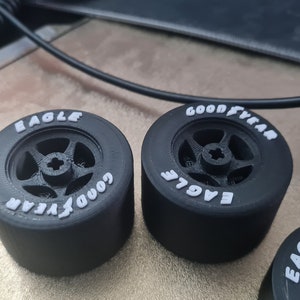 K&ouml;nnte beinhalten: Drei schwarze Gummireifen mit wei&szlig;er Beschriftung. Die Reifen sind mit "Goodyear Eagle" beschriftet und haben ein F&uuml;nf-Speichen-Rad-Design.