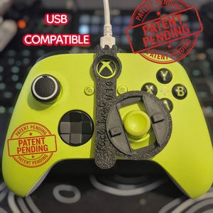May include: A lime green Xbox controller with black accents and a black attachment. The controller has the text "USB COMPATIBLE" and "PATENT PENDING" stamps. The controller is connected to a white USB cable.