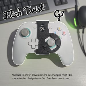Könnte beinhalten: Weißer Xbox-Controller mit einem schwarzen "Flick Twist" und "G7" Aufsatz. Der Controller hat farbige Tasten und einen schwarzen Aufsatz. Der Text unten lautet: "Product is still in development so changes might be made to the design based on feedback from user."