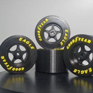 K&ouml;nnte beinhalten: Vier schwarze Goodyear Eagle Reifen mit gelber Beschriftung. Die Reifen sind &uuml;bereinander gestapelt.