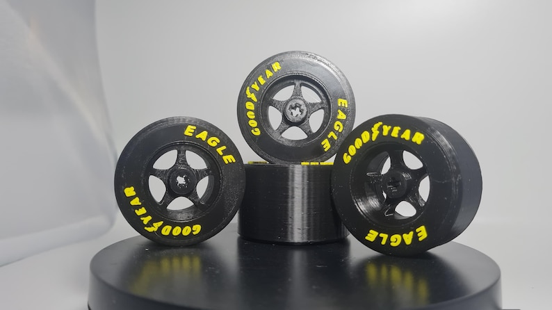 K&ouml;nnte beinhalten: Vier schwarze Goodyear Eagle Reifen mit gelber Beschriftung. Die Reifen sind &uuml;bereinander gestapelt.