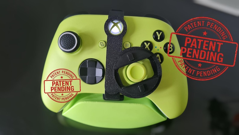 May include: A lime green Xbox controller with black accents and a black attachment. The controller has black buttons and a black joystick. The words "PATENT PENDING" are stamped on the controller in red.