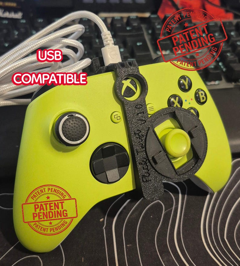 May include: A lime green Xbox controller with a black attachment and a white USB cable. The controller has black buttons and the text "USB COMPATIBLE". The image also includes a "Patent Pending" stamp.
