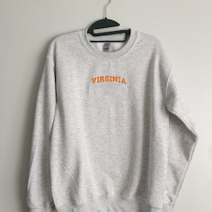 May include: A gray sweatshirt with the word "VIRGINIA" embroidered in orange on the front.