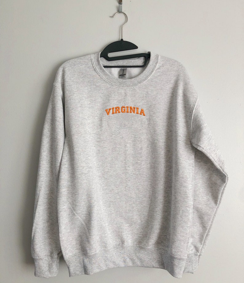 May include: A gray sweatshirt with the word "VIRGINIA" embroidered in orange on the front.