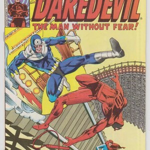 May include: A comic book cover featuring Daredevil, a superhero in a red suit, fighting a villain in a blue suit. The cover is titled "Daredevil" and "The Man Without Fear!" with a 40 pence price tag and a November 1979 date.