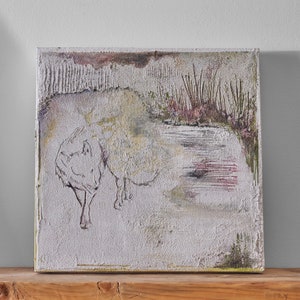 Op de afbeelding: Een wit, getextureerd canvas schilderij met een witte wolf of hond op de voorgrond en een vijver met riet op de achtergrond. Het schilderij is voornamelijk lichtgrijs, wit en groen.