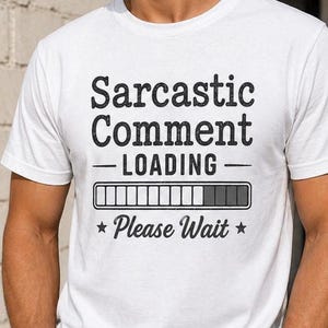 May include: White t-shirt with the text "Sarcastic Comment - LOADING - Please Wait" in black. The design includes a loading bar graphic. The shirt is a casual wear item.
