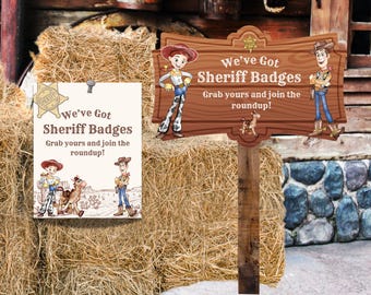 Puede incluir: Un letrero de madera y un letrero de papel con el texto "We've Got Sheriff Badges". Los letreros presentan ilustraciones de dibujos animados de una vaquera y un vaquero. Los letreros están colocados sobre un fondo de balas de heno y una estructura de madera rústica.