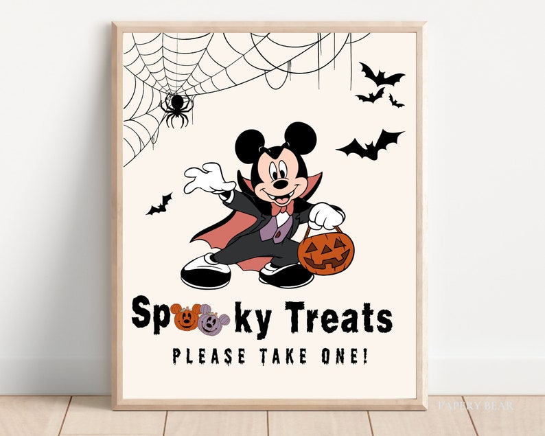 May include: A printable Halloween sign featuring a cartoon Mickey Mouse dressed as a vampire holding a jack-o-lantern. The sign says "Spooky Treats Please Take One!"