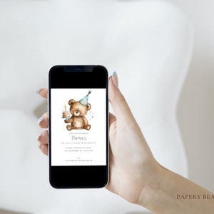 May include: A digital invitation for a first birthday party with a watercolor illustration of a brown bear wearing a blue and white party hat and holding a small cake with a single candle. The text on the invitation reads "Thomas's First Birthday".