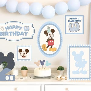 Könnte beinhalten: Eine Geburtstagsparty-Szene mit Mickey Mouse-Dekorationen. Enthält einen Kuchen, Luftballons und Schilder mit der Aufschrift "Happy Birthday" und "Mickey's Clubhouse". Das Farbschema ist hellblau, weiß, rot und gelb. Eine große Zahl "2" ist ebenfalls vorhanden.