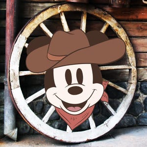 Op de afbeelding: Een cartoonafbeelding van Mickey Mouse met een bruine cowboyhoed en een rode bandana. Het personage staat tegen een achtergrond van een verweerd houten wagenwiel en een rustieke houten muur, wat een western thema oproept.