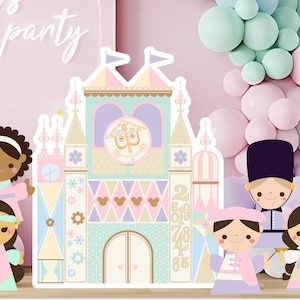 May include: A pastel-colored party decoration set featuring a whimsical castle and several cartoon figures. The castle has a clock face and is flanked by figures in various outfits. Balloons in pink, mint, and white create a festive backdrop. The words "let's party" are written in cursive.