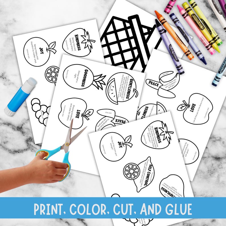 marble table background, has fruit papers with words like kindness, goodness, love, peace, gentleness, joy, self control, for each item from the Christian study lesson has blue stripe that says print, color, cut and glue. shows hand with scissors, glue stick, crayon.